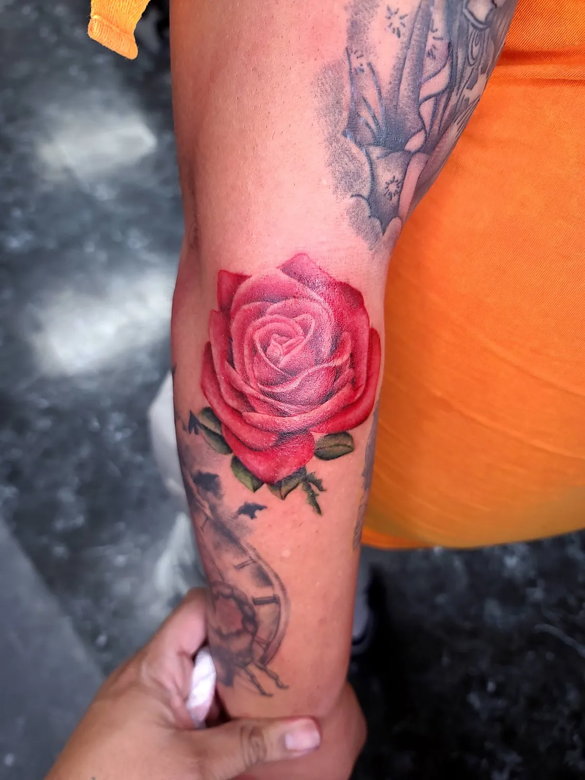 Realistic red rose forearm tattoo